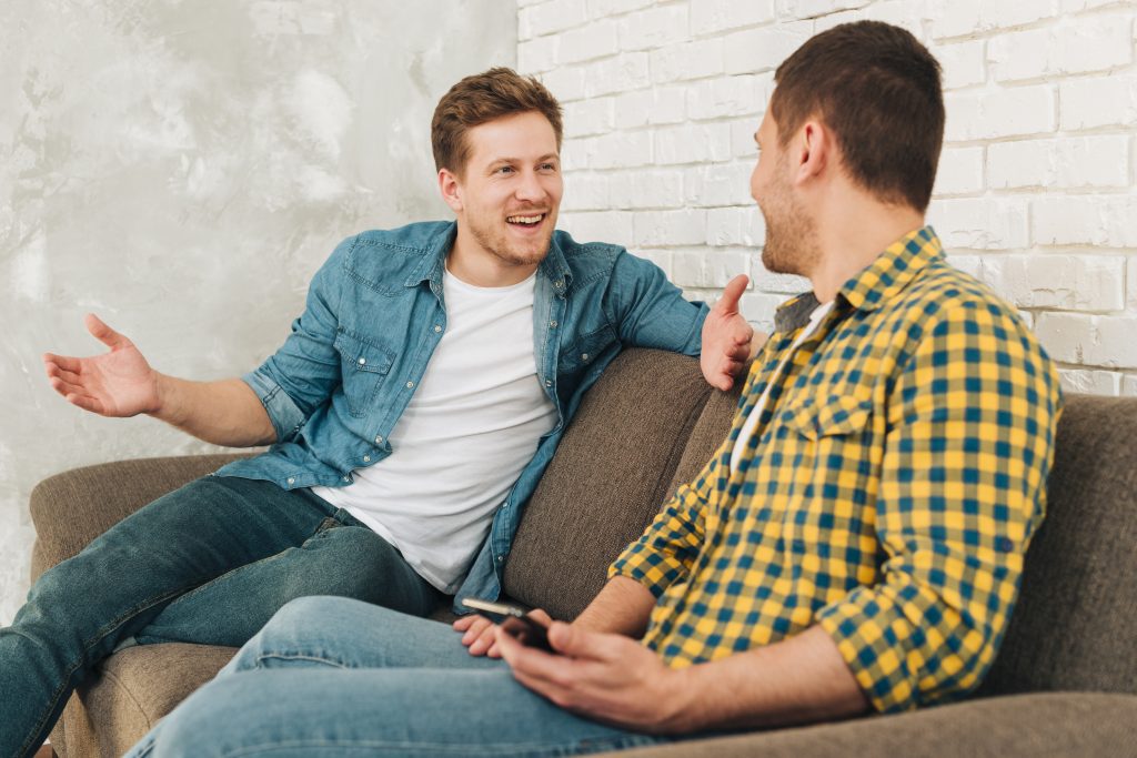 two-men-talking-on-sofa