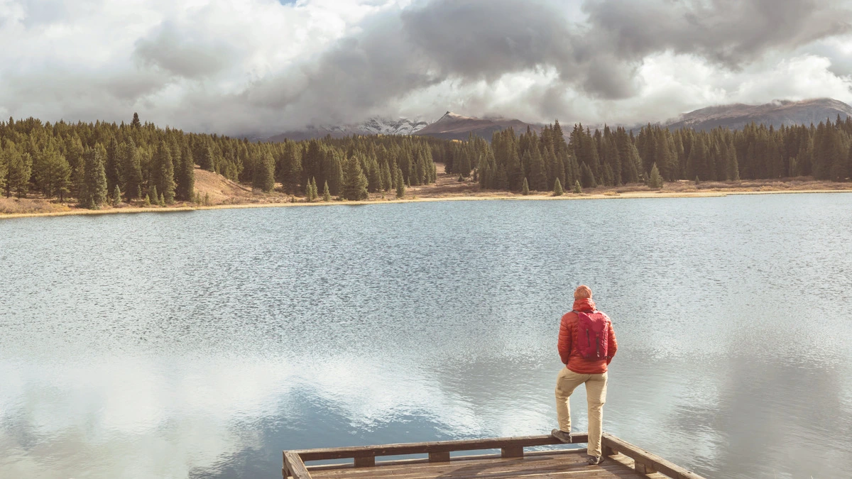 Comprehensive Alcohol Rehabilitation Program in Boulder - man standing at a lake surrounded by mountains