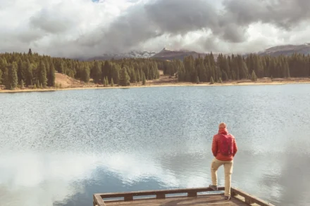 Comprehensive Alcohol Rehabilitation Program in Boulder - man standing at a lake surrounded by mountains